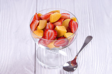 Salad of strawberry and apricot on a white table.