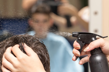 Rear view of man getting a haircut in beauty salon