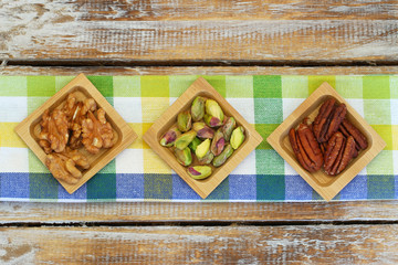 Pistachio, pecan nuts and walnuts on checkered cloth
