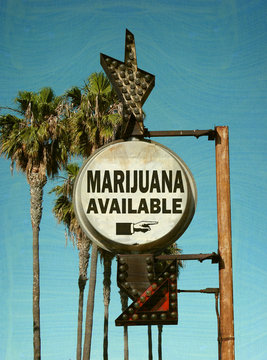 aged and worn vintage photo of marijuana sign with palm trees