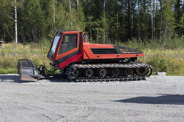 A snow preparing machine parked during the summer