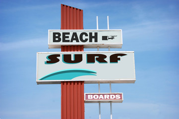aged and worn vintage surf sign on beach