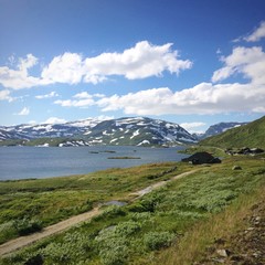 House near lakes and mountains. Spring landscape