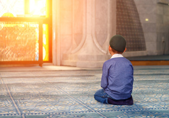 a little boy in the mosque - obrazy, fototapety, plakaty