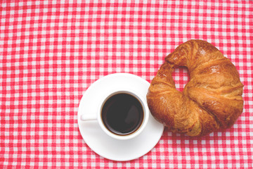 Coffee and croissant on table