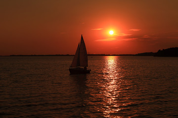 Żaglówka na jeziorze, zachód słońca.