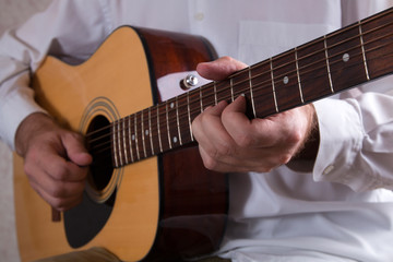 Fototapeta na wymiar Man playing the acoustic guitar close-up