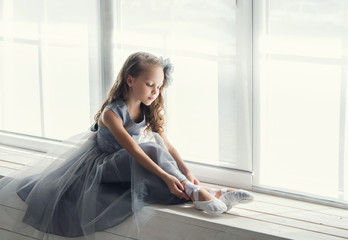 A little adorable young ballerina in a playful mood in the inter © jutaphoto