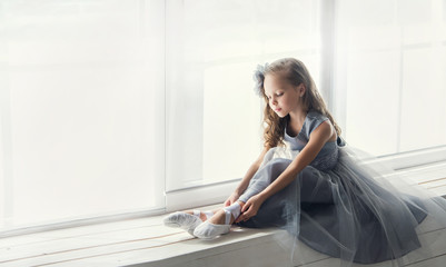 A little adorable young ballerina in a playful mood in the inter © jutaphoto