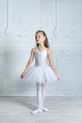 A little adorable young ballerina in a playful mood in the inter