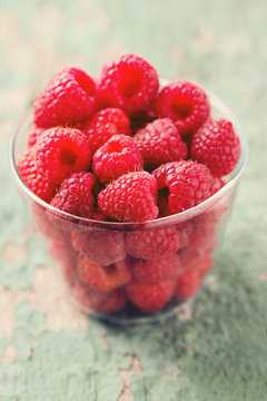 raspberry in a glass bowl on wooden surface
