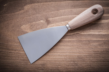 steel putty knife on wood board