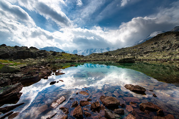 Fototapeta na wymiar Small high mountain lake with transparent