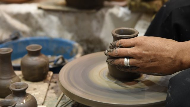 Hands working on pottery wheel, was produced on range of vase.