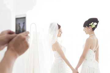 Fototapeta na wymiar Men are shooting a wedding between women in the smartphone