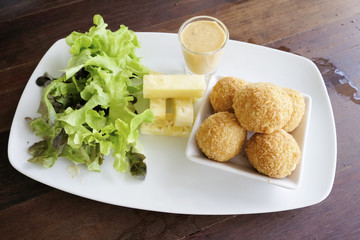 Fried cheese ball with salad in the dish
