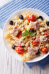 fusilli pasta with tuna, tomatoes and parmesan closeup. vertical top view
