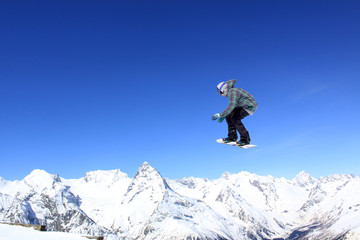 Fototapeta na wymiar Flying snowboarder on mountains
