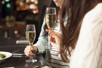 Young women are drinking champagne at the bar
