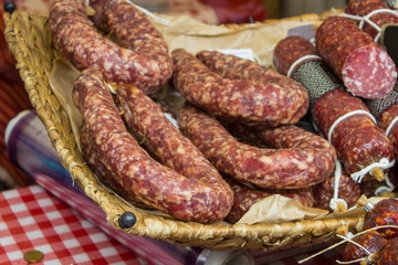 Freshly prepared raw sausage in basket on stall