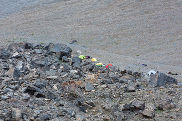 Camp on Rocky Moraine Many camping tents assembled on Rocky Slope along Mountain Creek