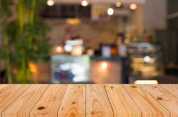 Selected focus empty brown wooden table and Coffee shop blur bac