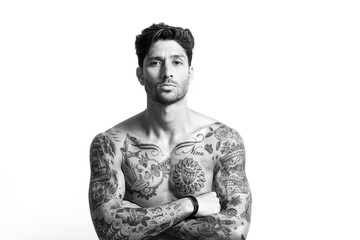 Sexy tattooed man portrait with crossed arms black and white