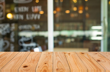 Selected focus empty brown wooden table and Coffee shop blur bac