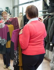 woman choosing     blouse in    store.