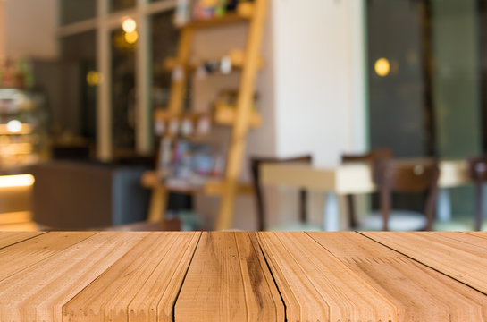 Selected focus empty brown wooden table and Coffee shop blur bac