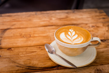 Hot art Latte Coffee in a cup on wooden table.