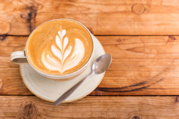 Hot art Latte Coffee in a cup on wooden table.