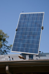 Two male solar workers install solar panels on home in Oak View, Southern California.