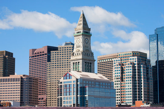 Commerce House Tower (built 1910) and Boston Skyline with white puffy clouds as photographed from Lewis Wharf, Boston, MA.