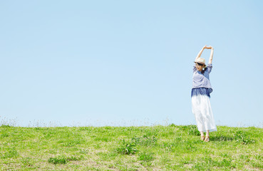 丘に立つ女性　背伸び