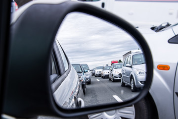 Traffic jam view through a side view car mirror