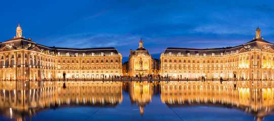 Panoramic view of Place la Bourse in Bordeaux, reflections in the water mirror illuminated at night, France - obrazy, fototapety, plakaty