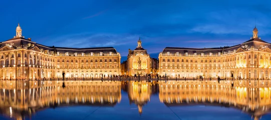 Fotobehang Panoramic view of Place la Bourse in Bordeaux, reflections in the water mirror illuminated at night, France © Delphotostock