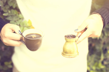 Girl keeping a cup of coffee and a turk, vintage photo effect
