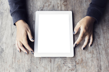Girl hands with blank digital tablet on a wooden table, mock up