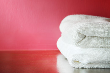 Stacked White Spa Towels on Red Background.