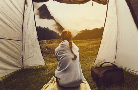Woman watches landscape from tent