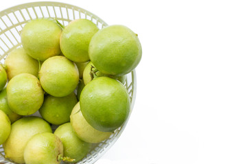 fresh limes in plastic basket on white