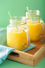 healthy yellow smoothie with mango pineapple banana in mason jar