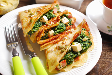 spinach and feta filled pancakes on wooden table