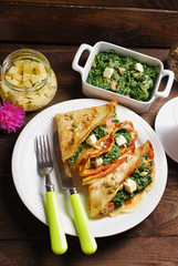 spinach and feta filled pancakes on wooden table