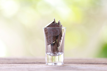silver coin in glass is placed on a wood floor with colorful bok