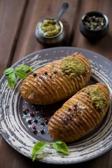 Hasselback potato with basil pesto, selective focus, close-up