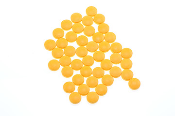 Yellow pills on white background