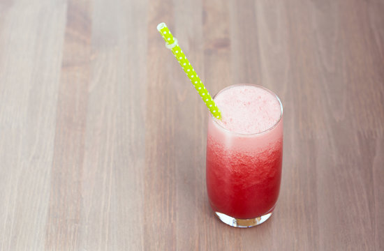 A glass of healthy watermelon smoothie on wooden background